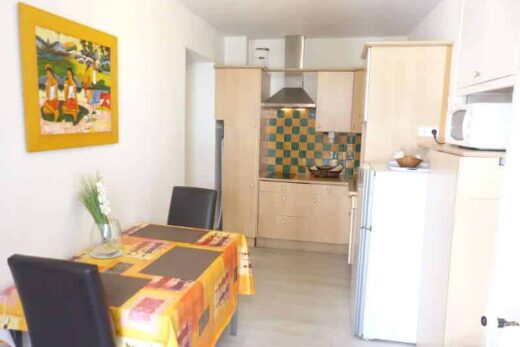 Amelie les bains location daviaud, photo de la cuisine avec table pour manger du studio n°C8 avec balcon donnant sur la rue Castellane. Cette location se trouve à 100 mètres des thermes.