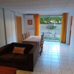 Vue du salon séjour avec accès au jardin privatif de la location F2 n°314 loué par la Résidence le Catalogne** à Amélie les bains